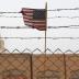 An American flag is seen behind barbed wire at the former U.S. Sather Air Base near Baghdad, Iraq December 14, 2011.
