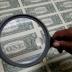 United States one dollar bills are inspected under a magnifying glass during production at the Bureau of Engraving and Printing in Washington November 14, 2014. REUTERS/Gary Cameron 