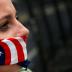 A supporter of U.S. Senator Bernie Sanders covers her mouth with a bandana in the colors of the American flag while standing along the perimeter fence of the 2016 Democratic National Convention in Philadelphia, Pennsylvania on July 28, 2016. REUTERS/Adree