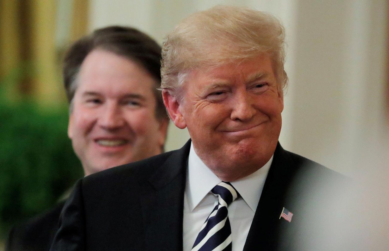 U.S. President Donald Trump smiles next to U.S. Supreme Court Associate Justice Brett Kavanaugh as they participate in a ceremonial public swearing-in in the East Room of the White House in Washington, U.S., October 8, 2018. REUTERS/Jim Bourg